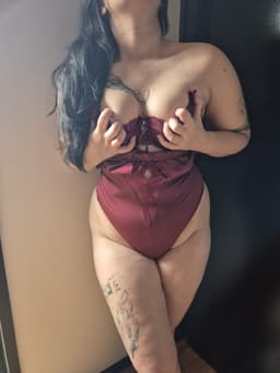 A woman in red lingerie offers a sensual massage, captivating with her allure and graceful touch.