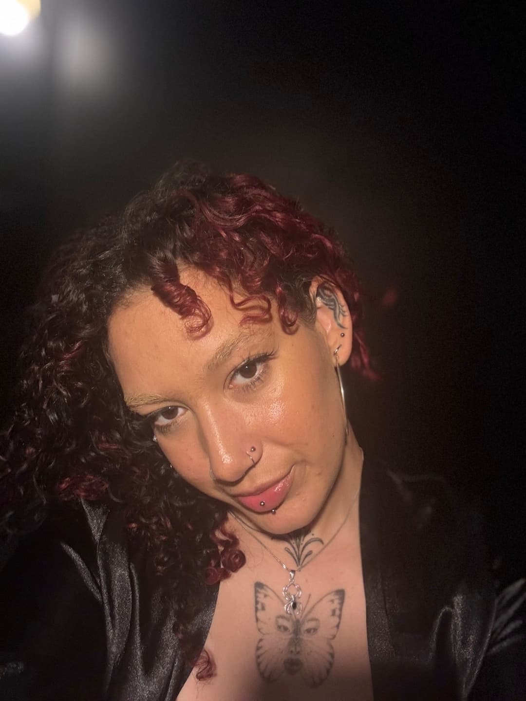 Azara Sin in a close-up portrait with curly hair and tattoos during a sensual, tantra-inspired moment in Melbourne