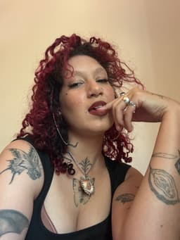 Azara Sin in a close-up portrait with curly hair and tattoos during a sensual, tantra-inspired moment in Melbourne