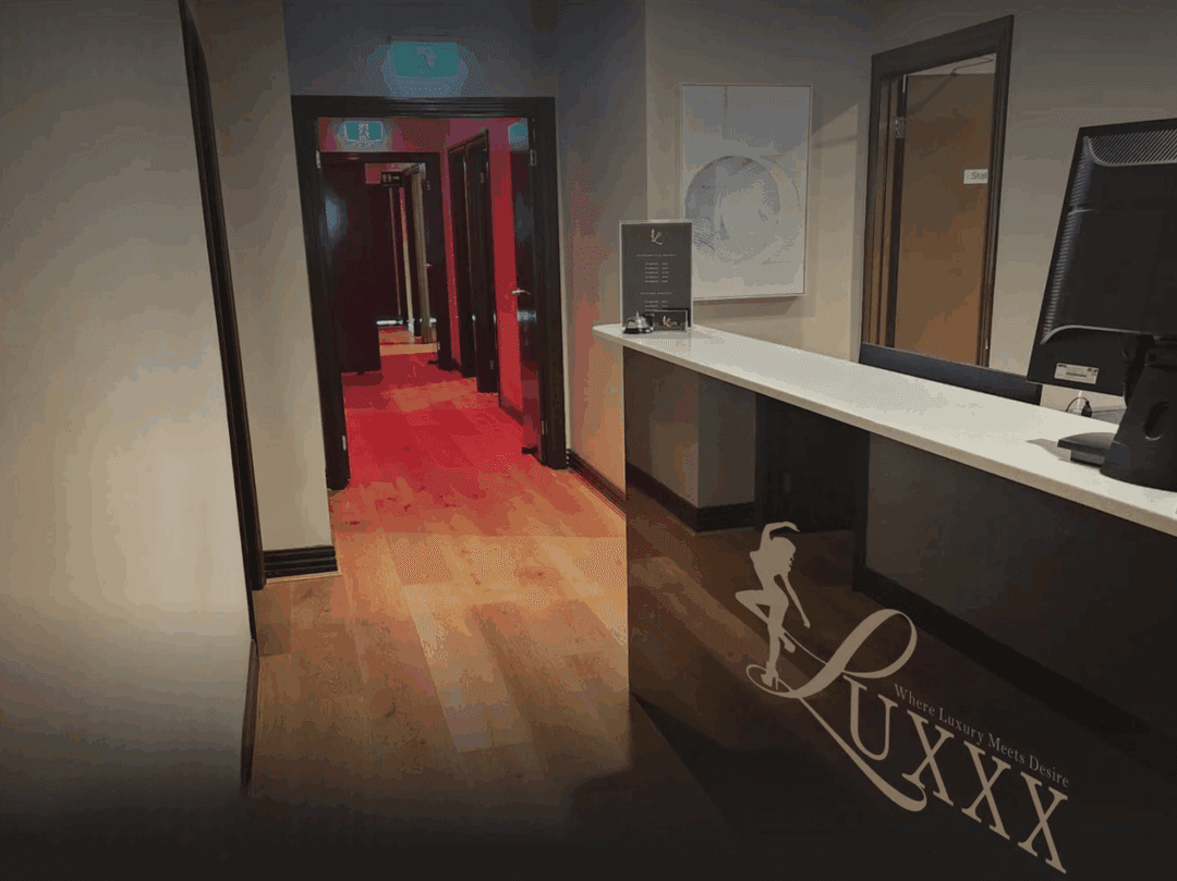 Reception area and red-lit hallway inside Luxxx Erotic Massage in Melbourne, creating a luxurious and intimate atmosphere