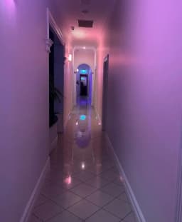 Adult massage Adelaide hallway with tiled floor and violet lighting