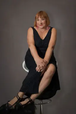 Ally Thomas, tantric massage Adelaide practitioner, seated in a black dress Ally Thomas, tantric massage Adelaide practitioner, seated in a black dress