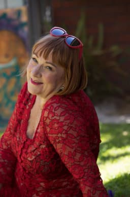 Ally Thomas, tantric massage practitioner in Adelaide, smiling in a red lace top Ally Thomas, tantric massage practitioner in Adelaide, smiling in a red lace top