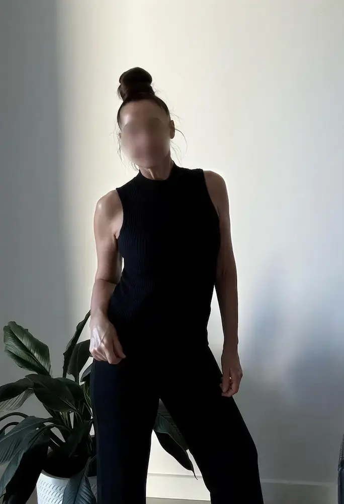 Perth erotic massage, brunette masseuse in a black high neck top, backlit against a white wall Perth erotic massage, brunette masseuse in a black high neck top, backlit against a white wall